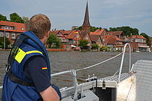 Die THW-Kräfte kontrollieren vom Boot aus die Wasserstände an der Lauenburger Altstadt und sammeln Treibgut auf. Quelle: THW